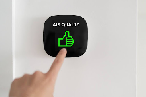 A hand reaching for a screen that says "air quality" with a green thumbs-up.